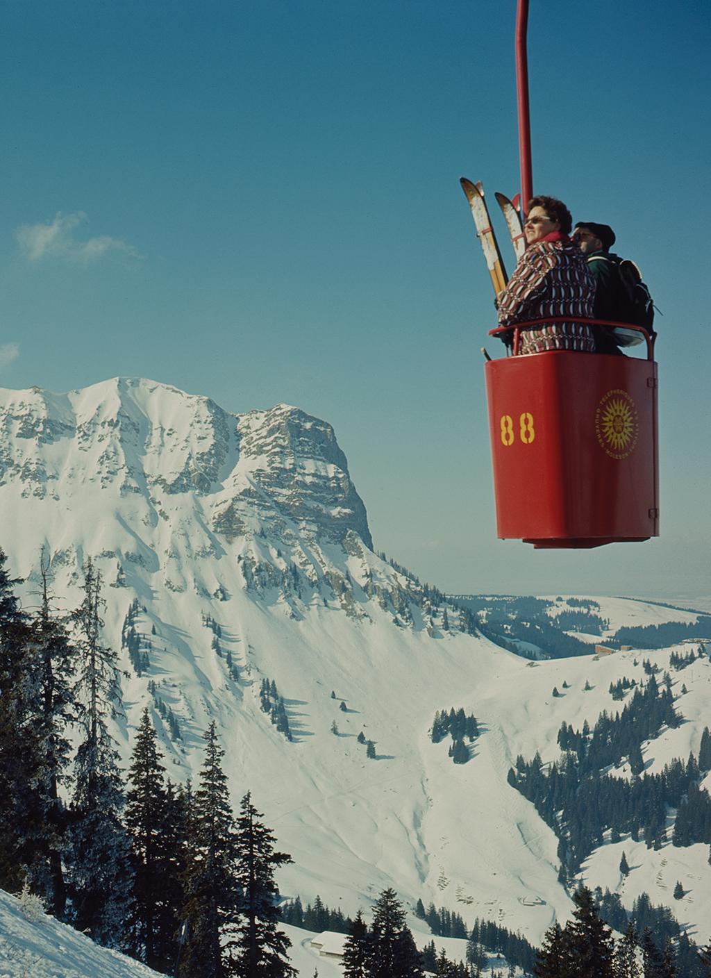 Open-air cable car carrying two people.