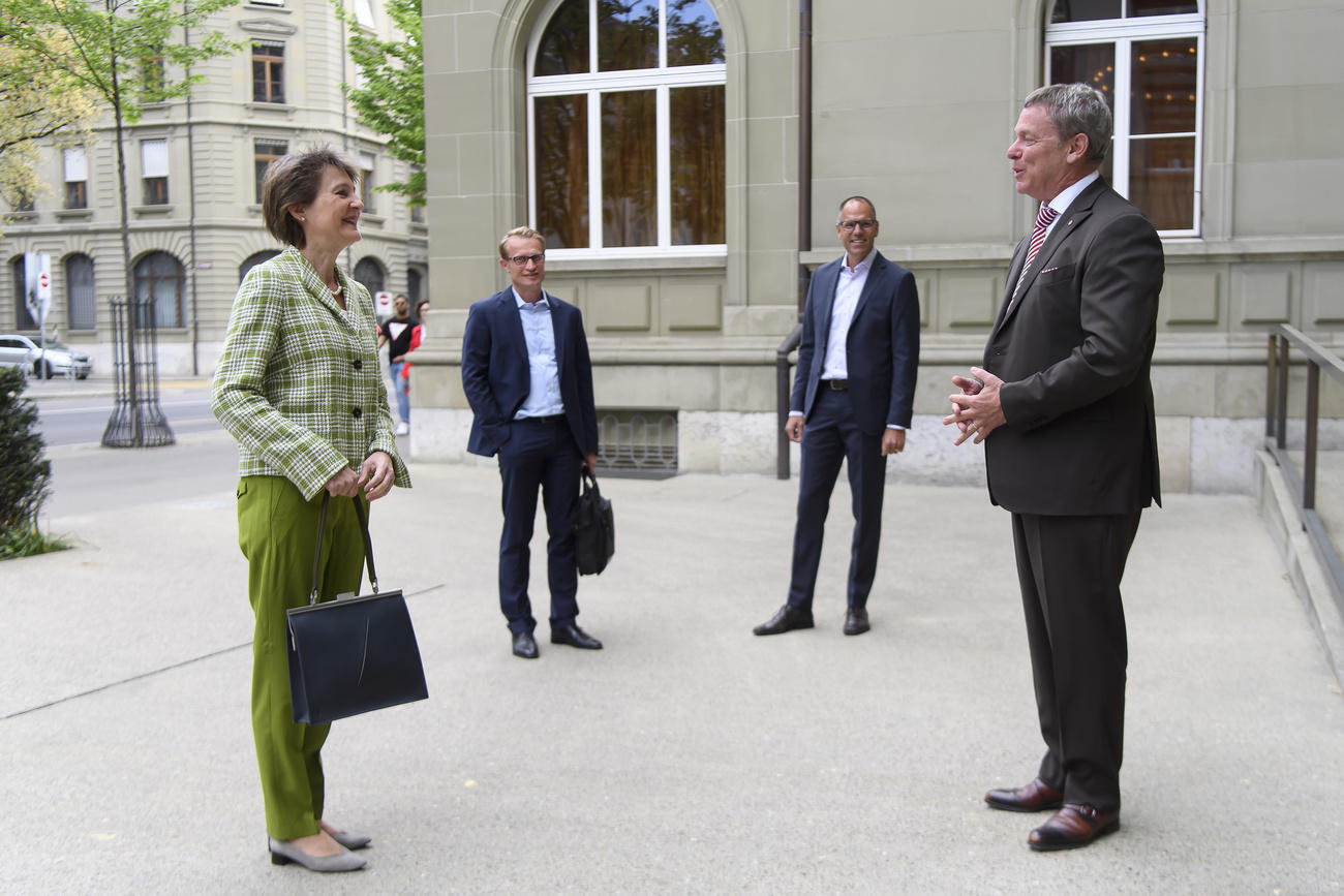 President Sommaruga and three men waiting outside a building