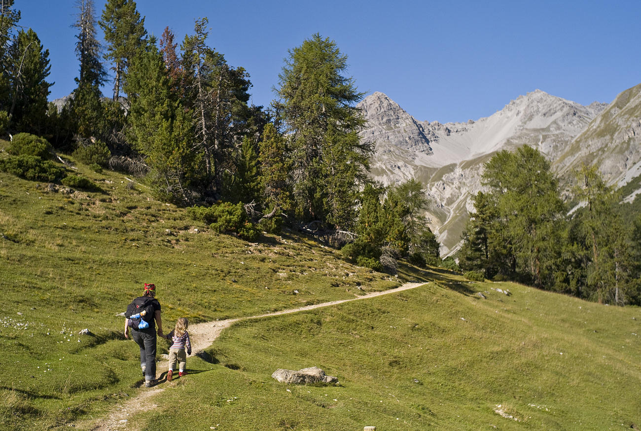 Eine Frau und ein Kind spazieren auf einem Wanderweg.