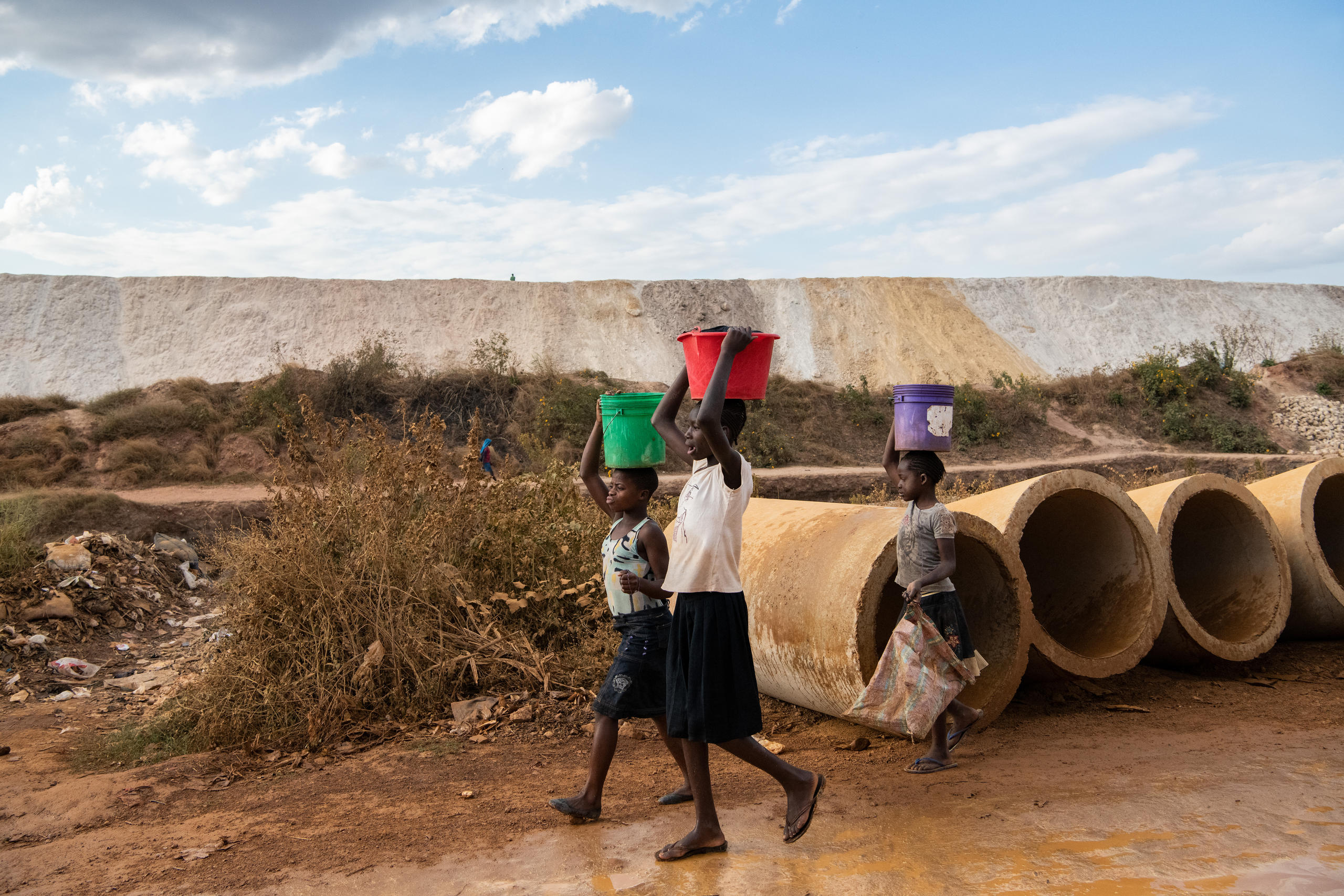 Children walk past copper mine