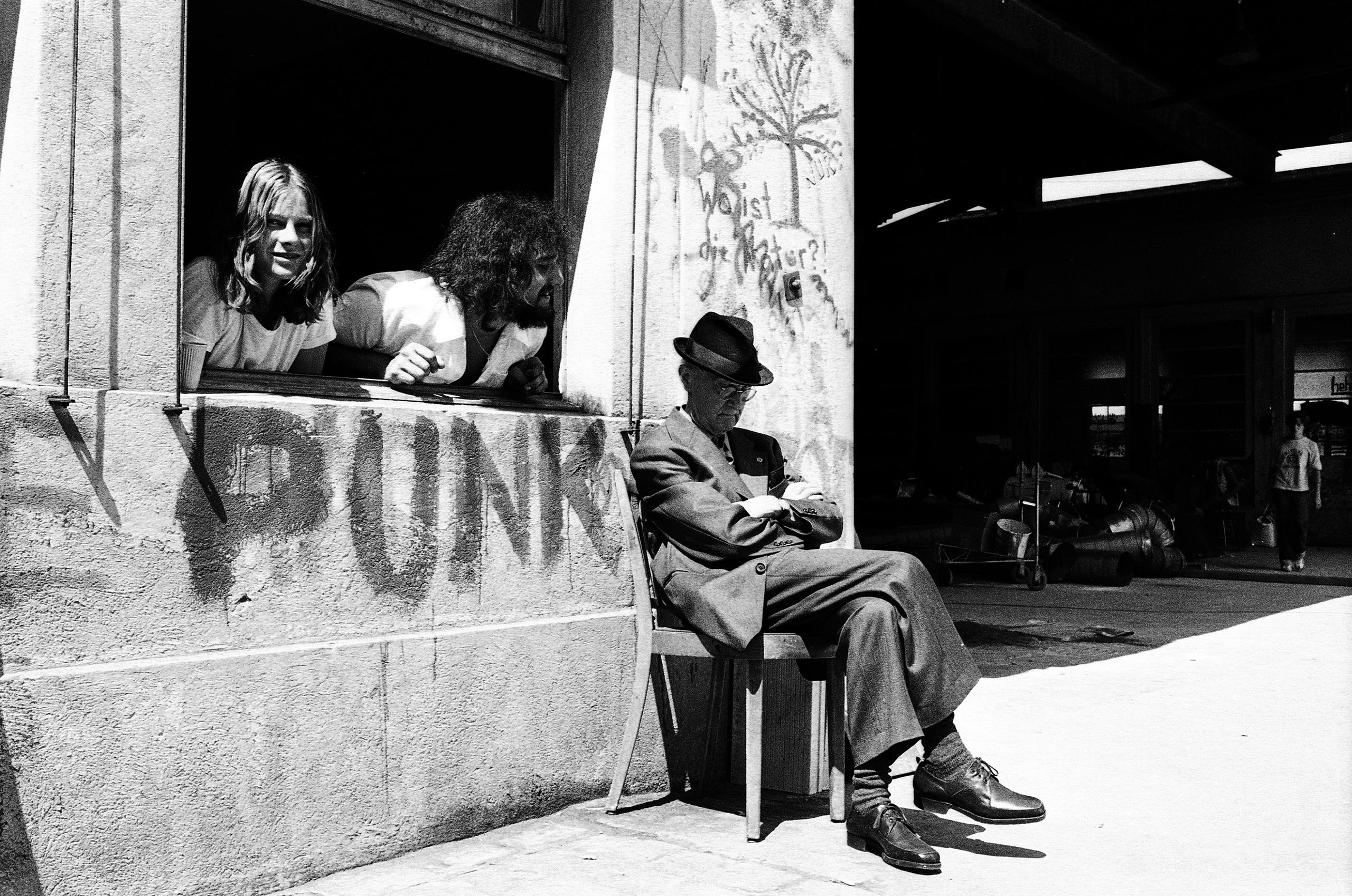 Un anciano sentado al sol y dormitando junto al Centro Juvenil Autónomo