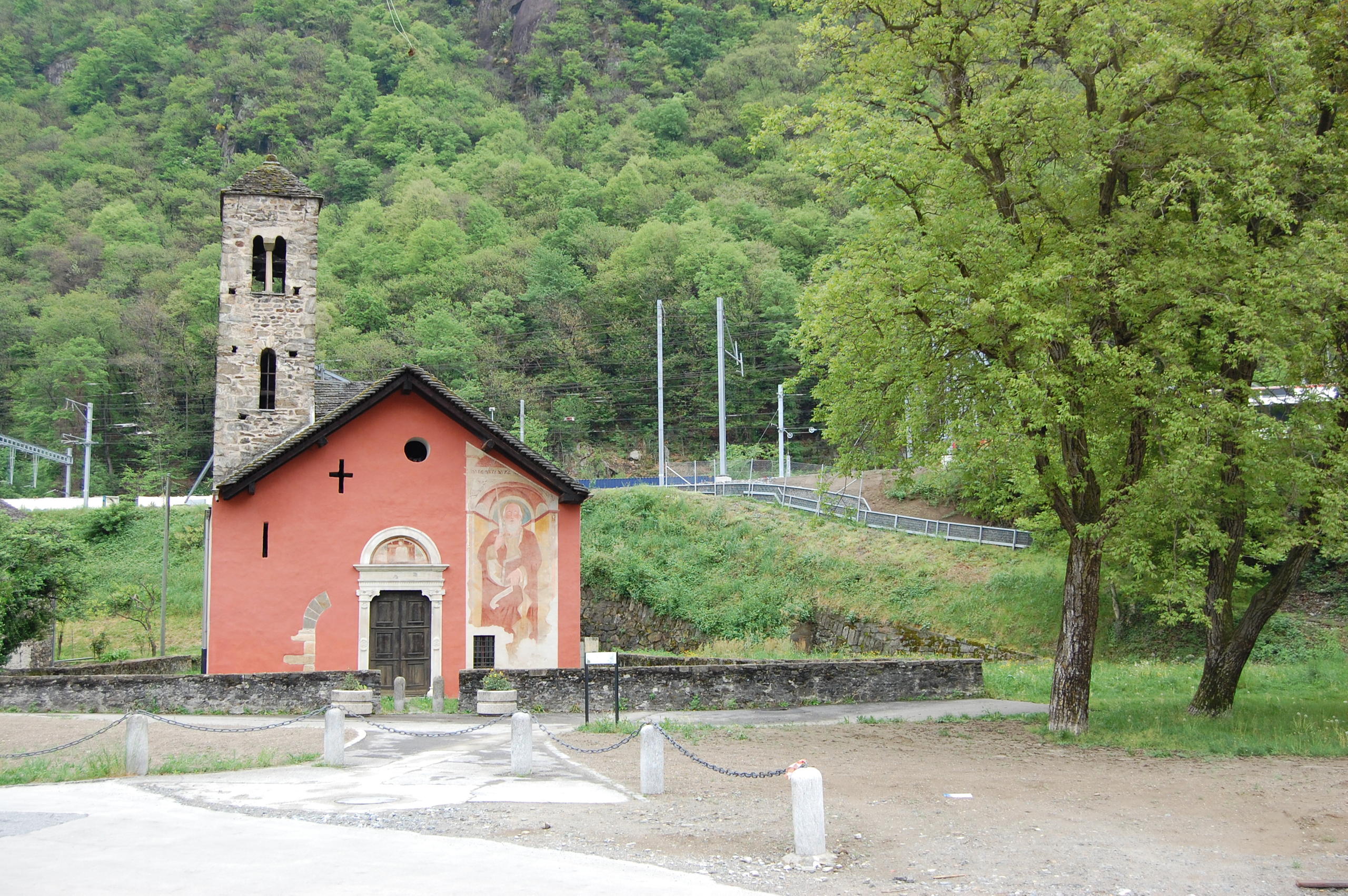 chiesa storica con una facciata rossa sul cui lato destro c è un affresco iconografico di San Paolo sulla destra