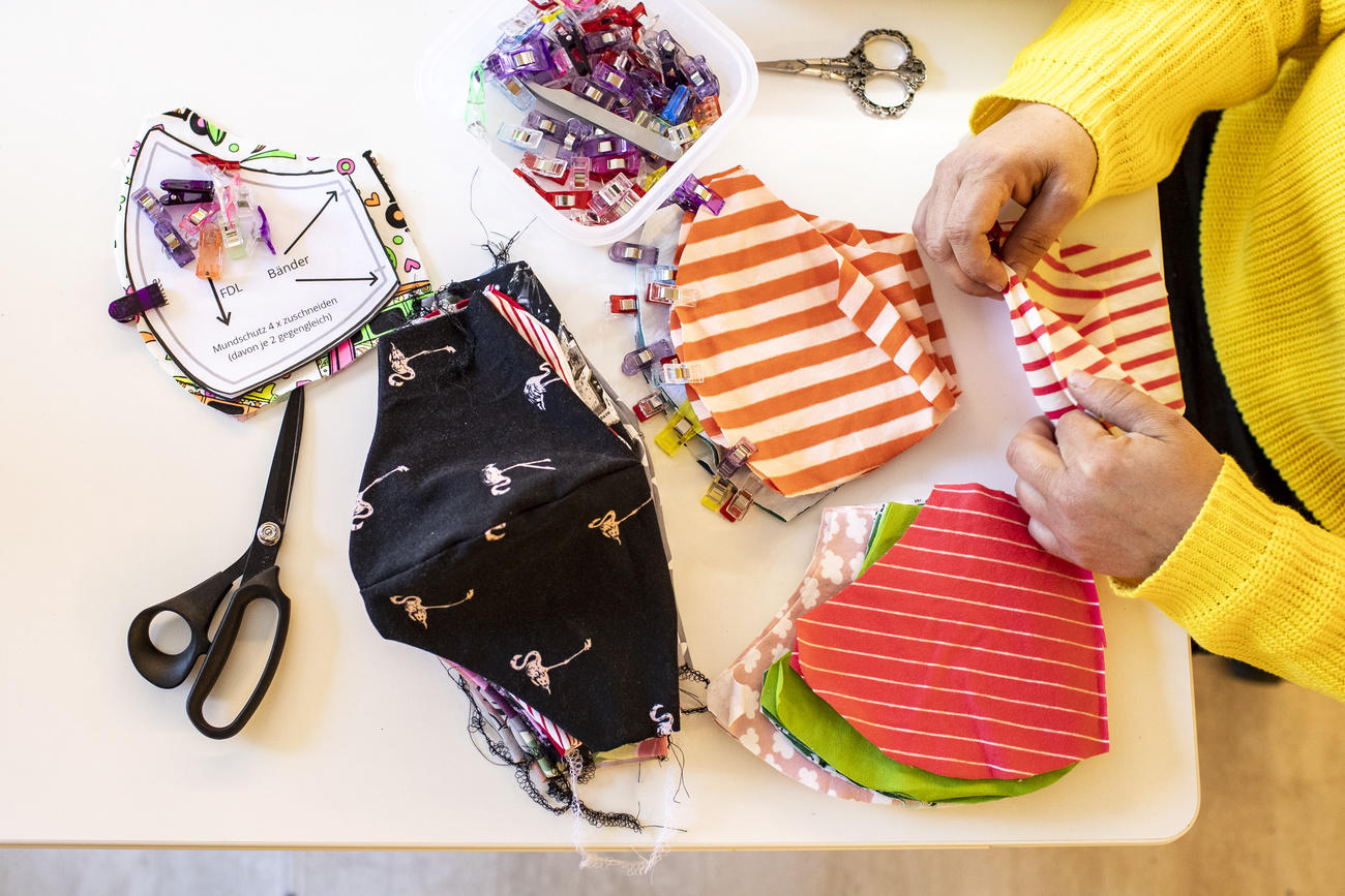 A woman makes a protective face mask out of pieces of material in Zug on April 6, 2020 (KEYSTONE/Alexandra Wey).