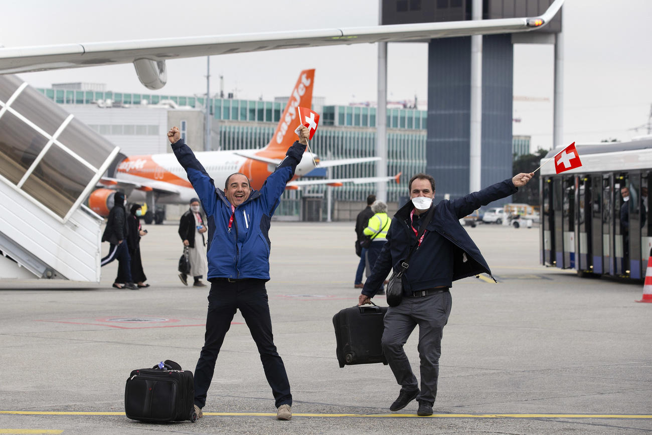 In the picture, two passengers return to Geneva from Algiers, Algeria, on March 29.