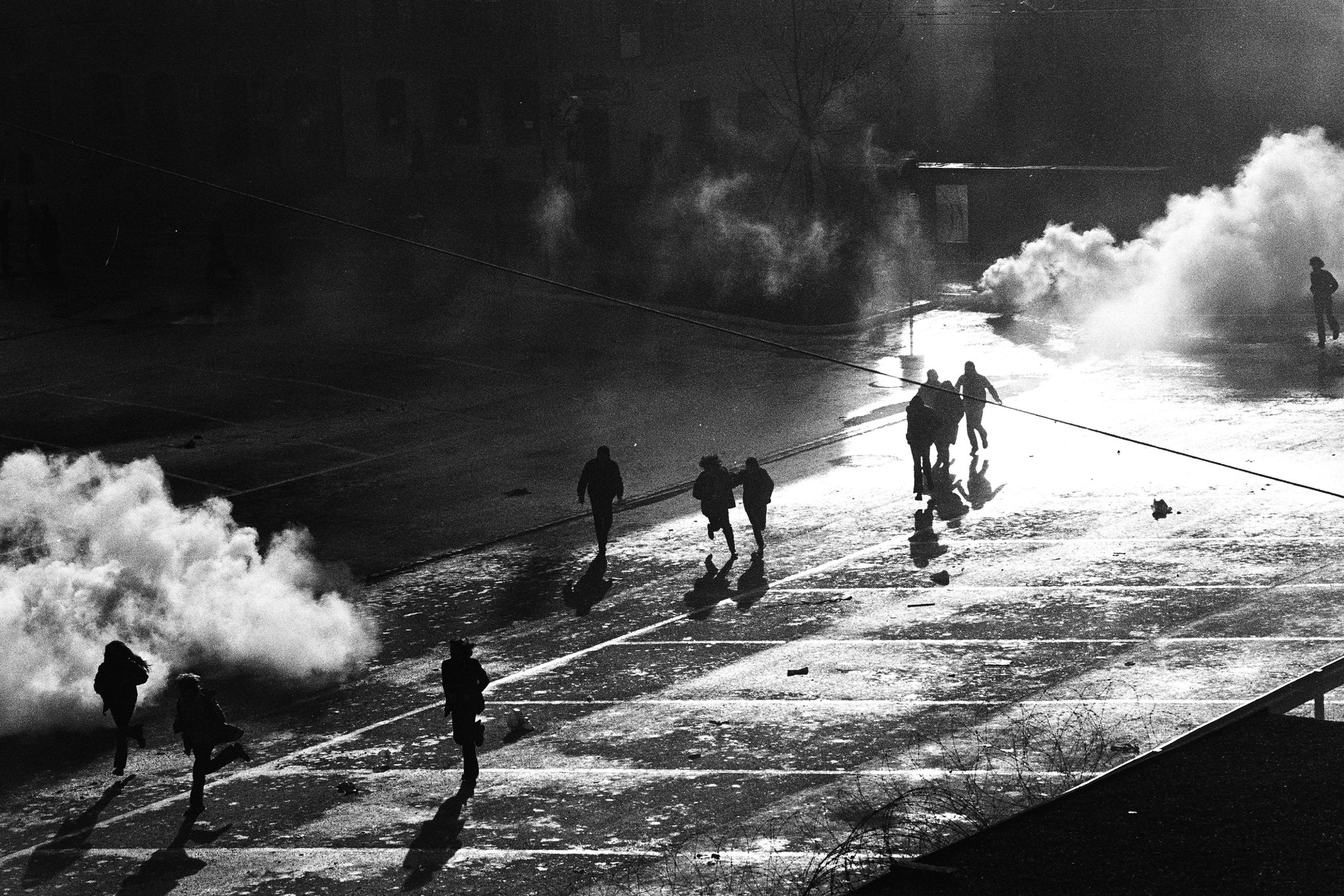 Manifestantes huyen de las nubes de gas lacrimógeno