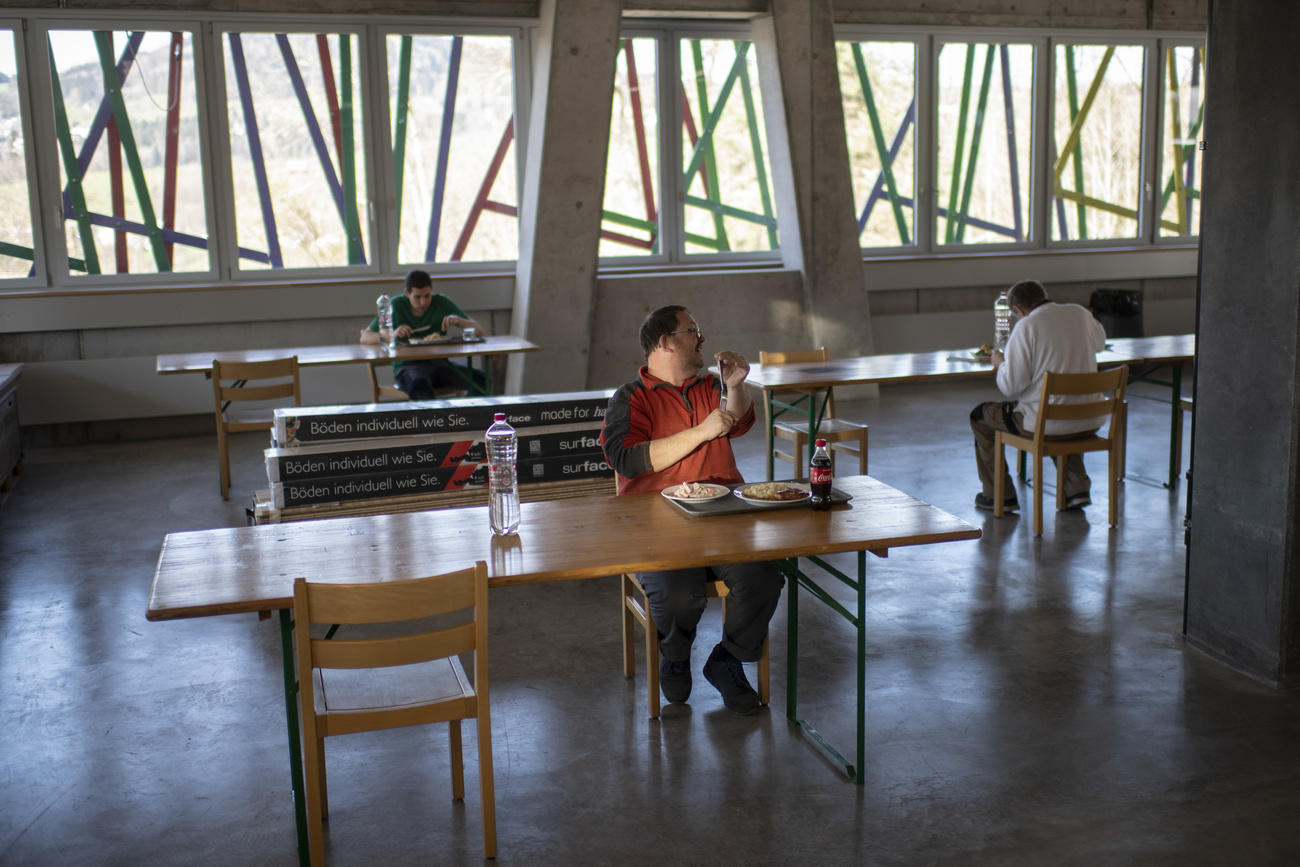 Handicapés mentaux mangeant seuls à des tables