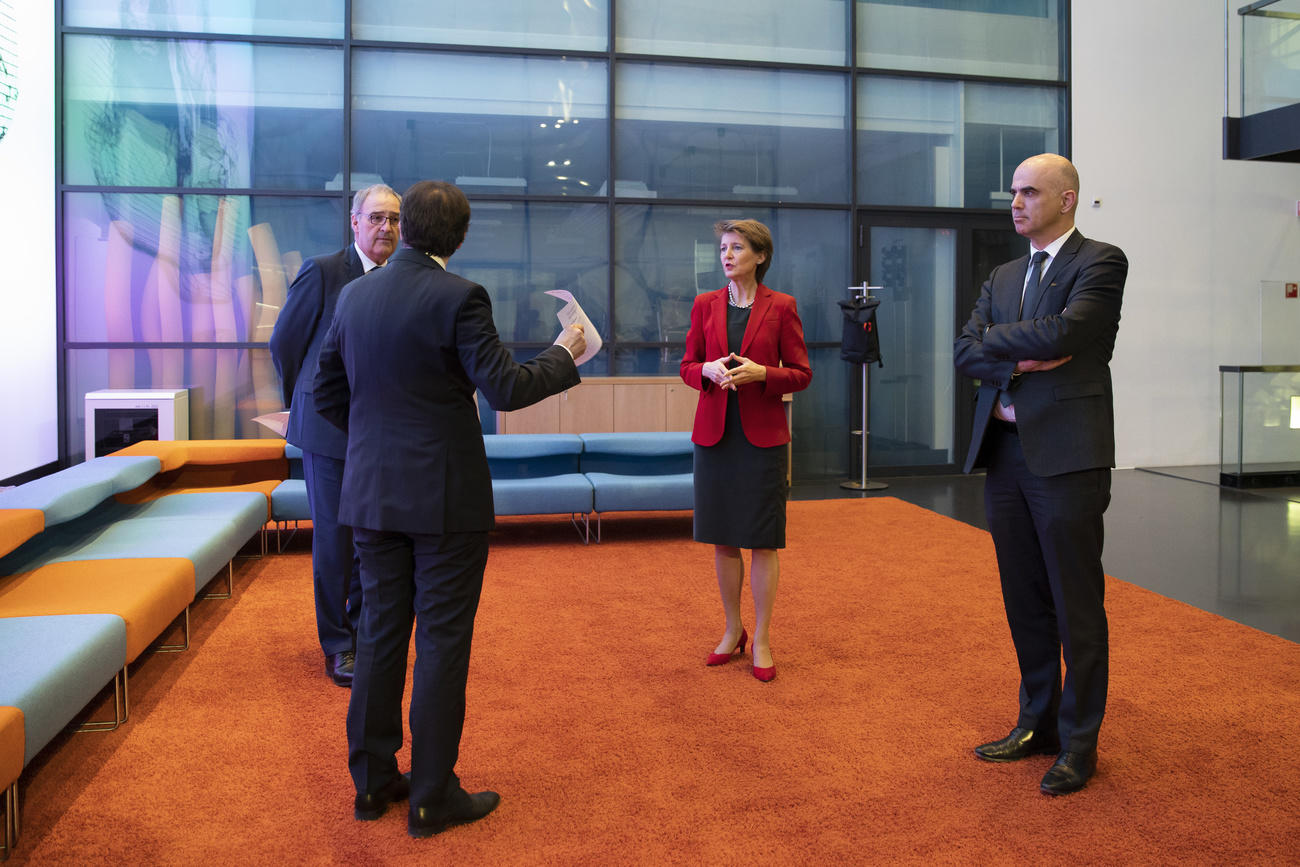 Four people standing on an orange carpet