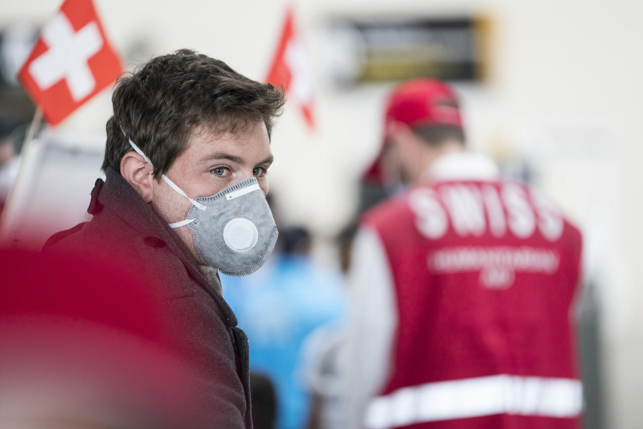 Mann mit Mundschutz wartet auf Heimflug