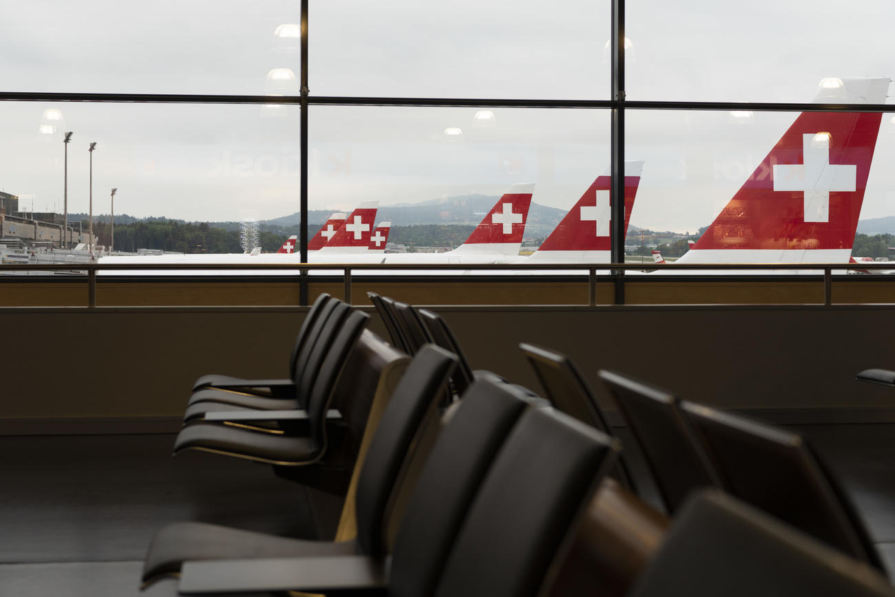 Planes by Swiss International Airlines and empty passenger area at airport
