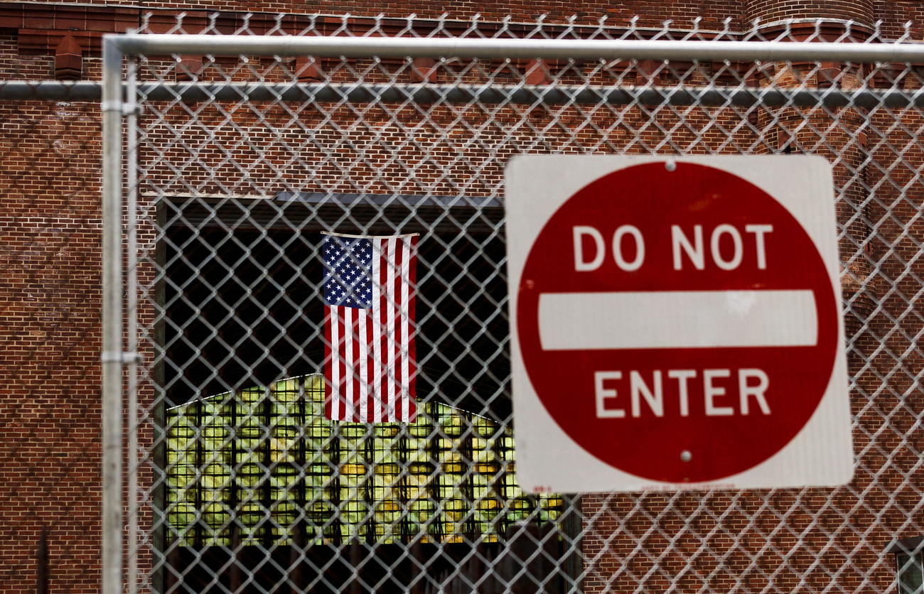Immigrazione temporaneamente sospesa negli USA: nella foto un cartello con la scritta Do not enter con dietro la bandiera USA.