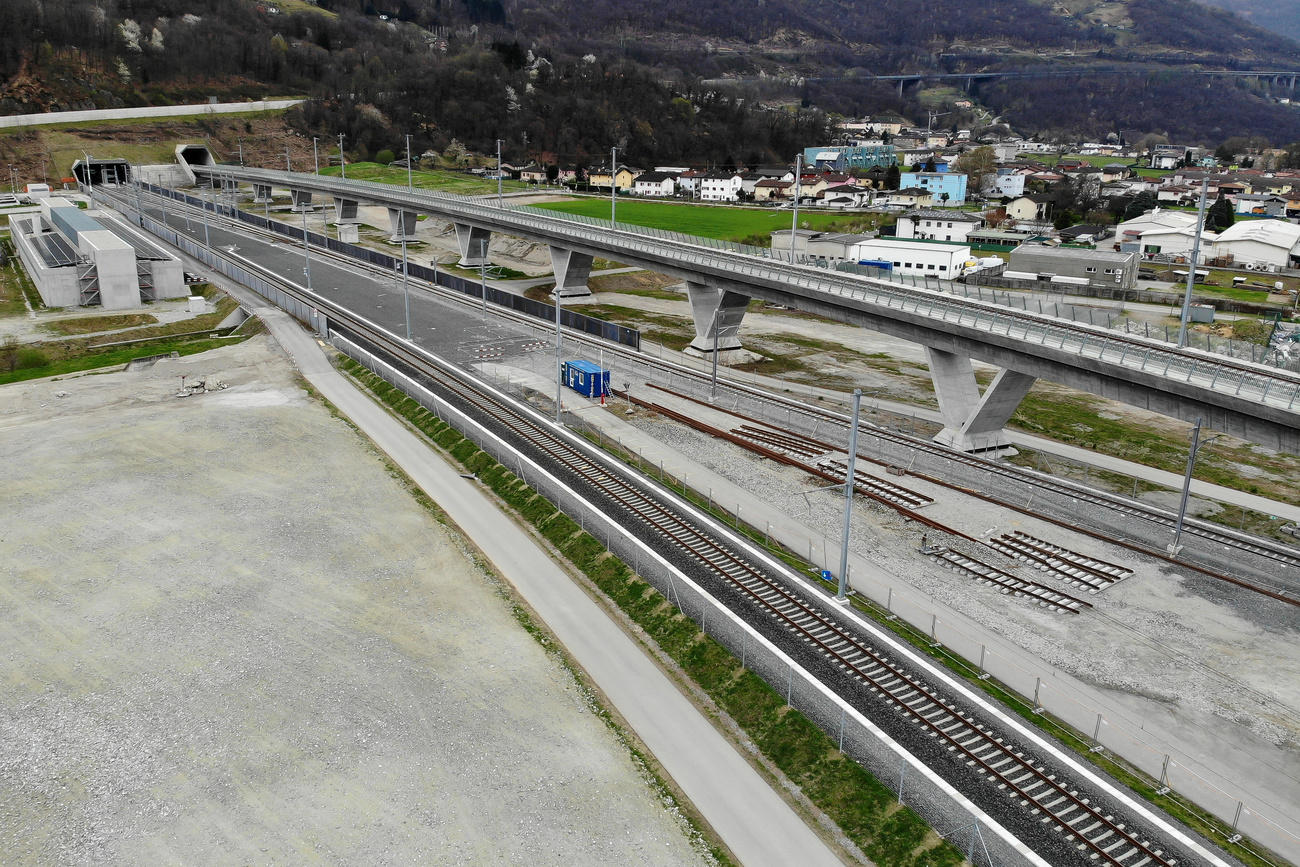 Immagini di due lunghi viadotti ferroviari accanto a campi coltivati e poco abitato che sfociano nell imbocco di un tunnel