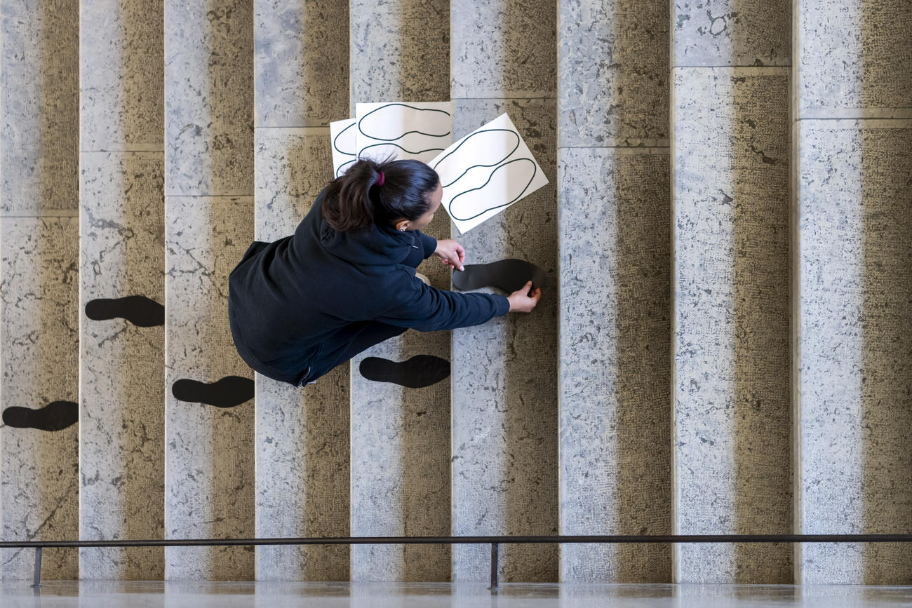 woman putting stickers with footsteps on set of stairs