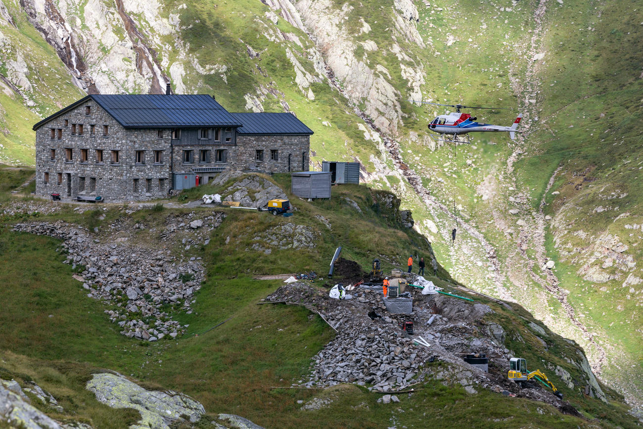 A helicopter transports material for the construction of the water purification system of the SAC s Terri Mountain Hut