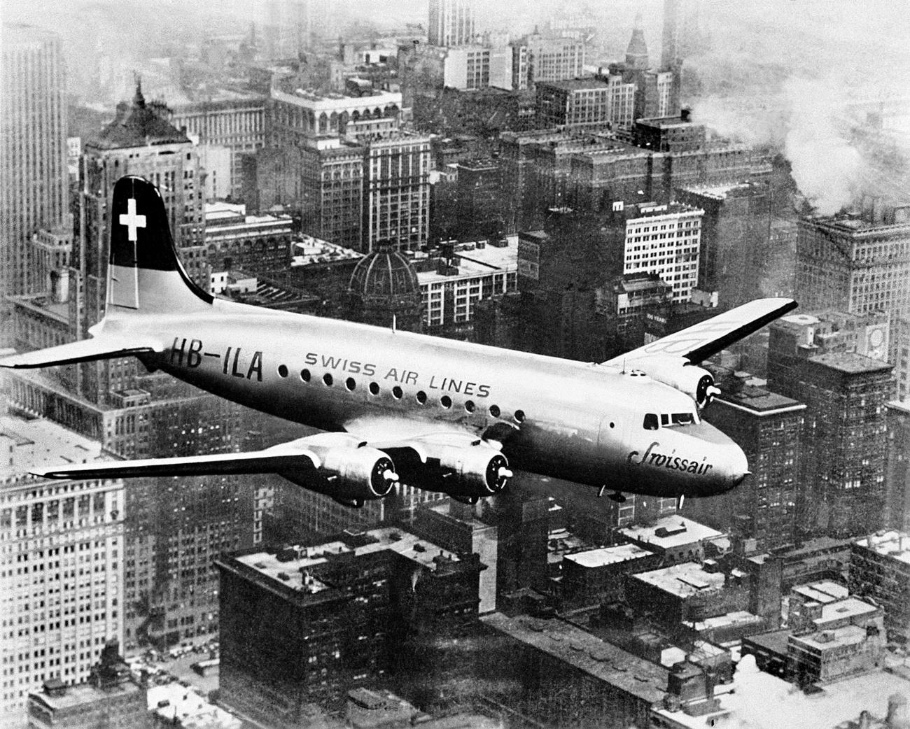 从纽约直飞日内瓦的一架瑞航DC-4班机正飞经纽约市摩天大楼的上空，照片摄于1947年5月。