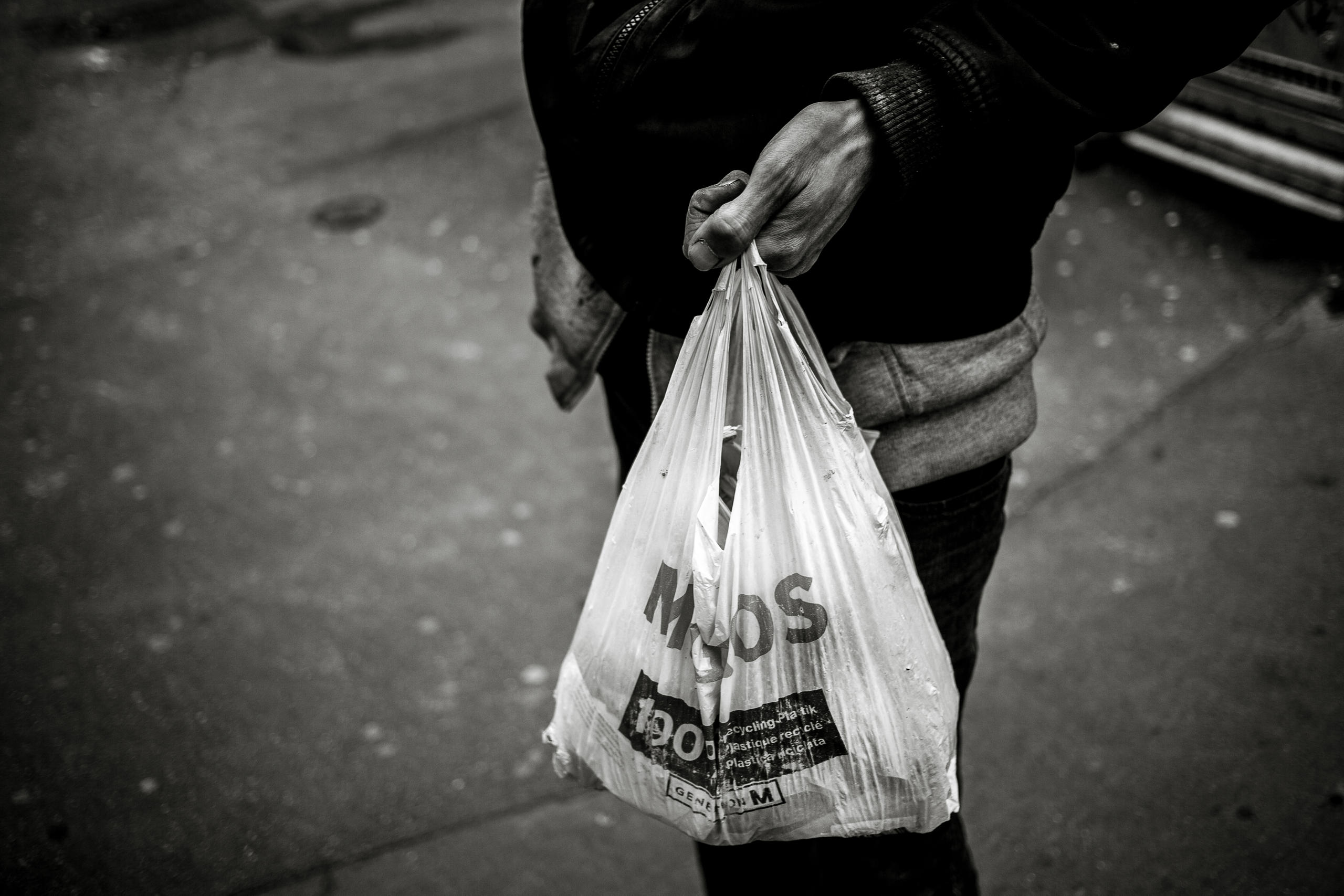 Une personne porte un sac plastique