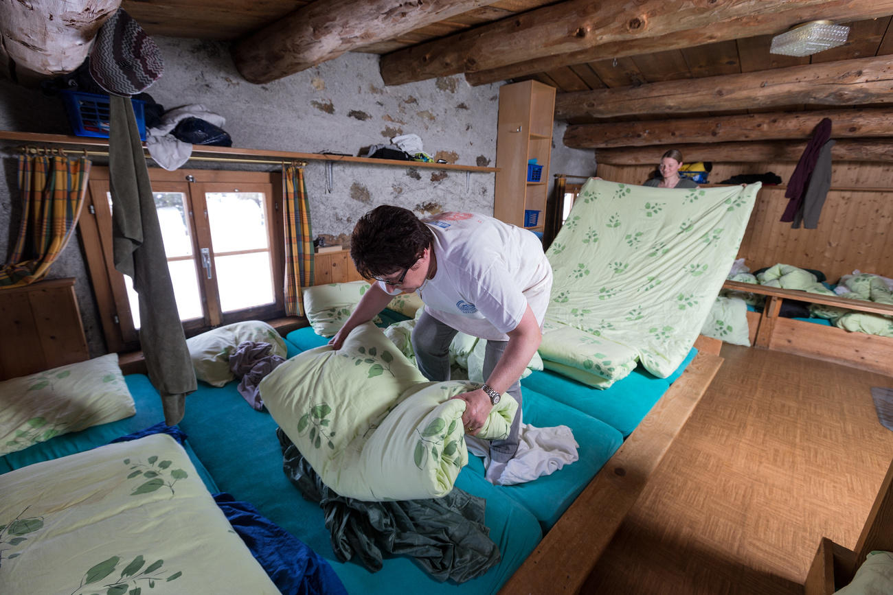 小屋的员工在Saoseo小屋的宿舍里整理床铺。保持社交距离意味着今年夏天床位无法实现满客。
