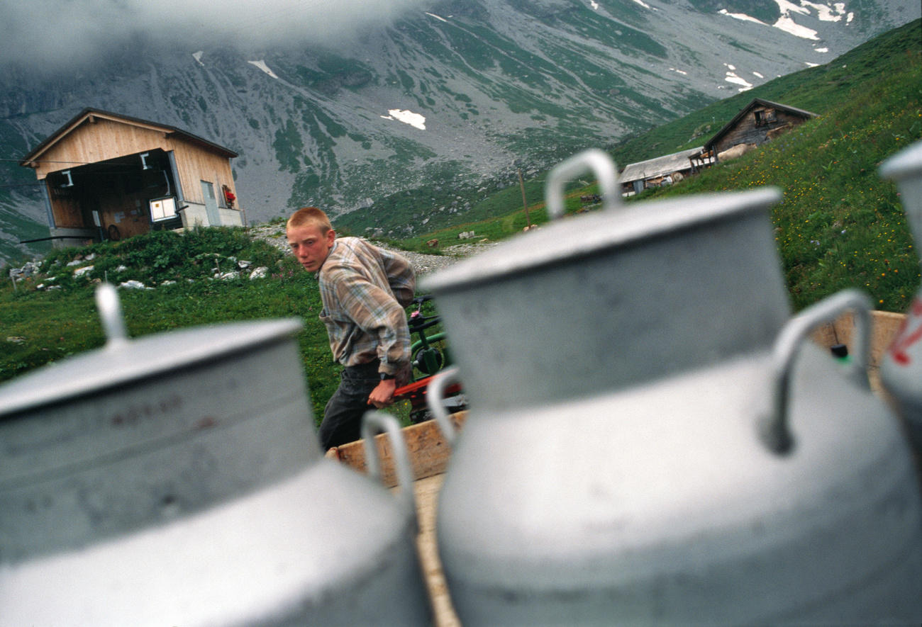 Young alpine farmer with milk cans