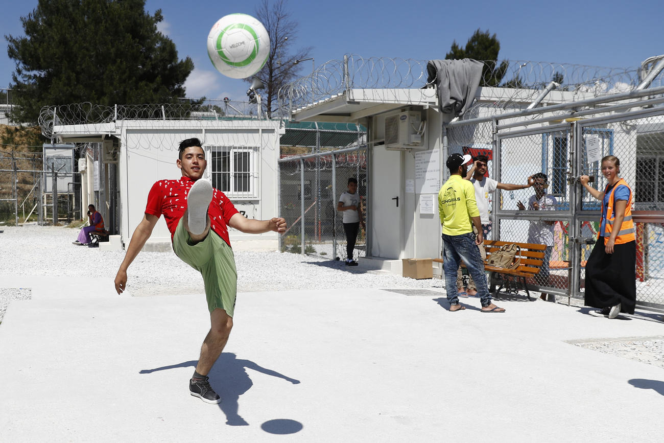 Teenager playing football in a refugee camp