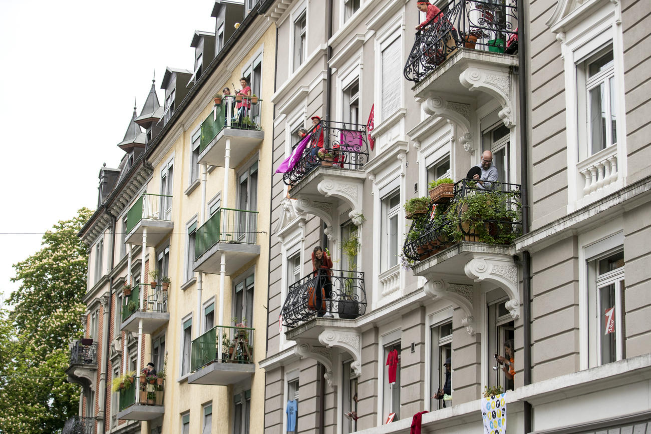 Gente asomada al balcon en edificios de Zúrich.