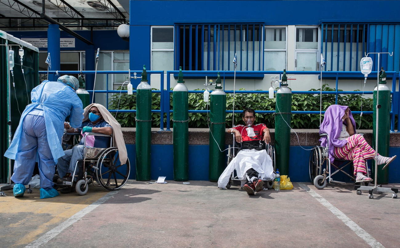 Tre pazienti attaccati alle bombole di ossigeno in un ospedale Perù e stazionati sui posteggi davanti al nosocomio.