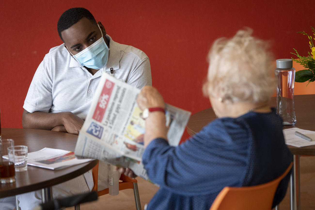 A young soldier talking to an elderly care home resident