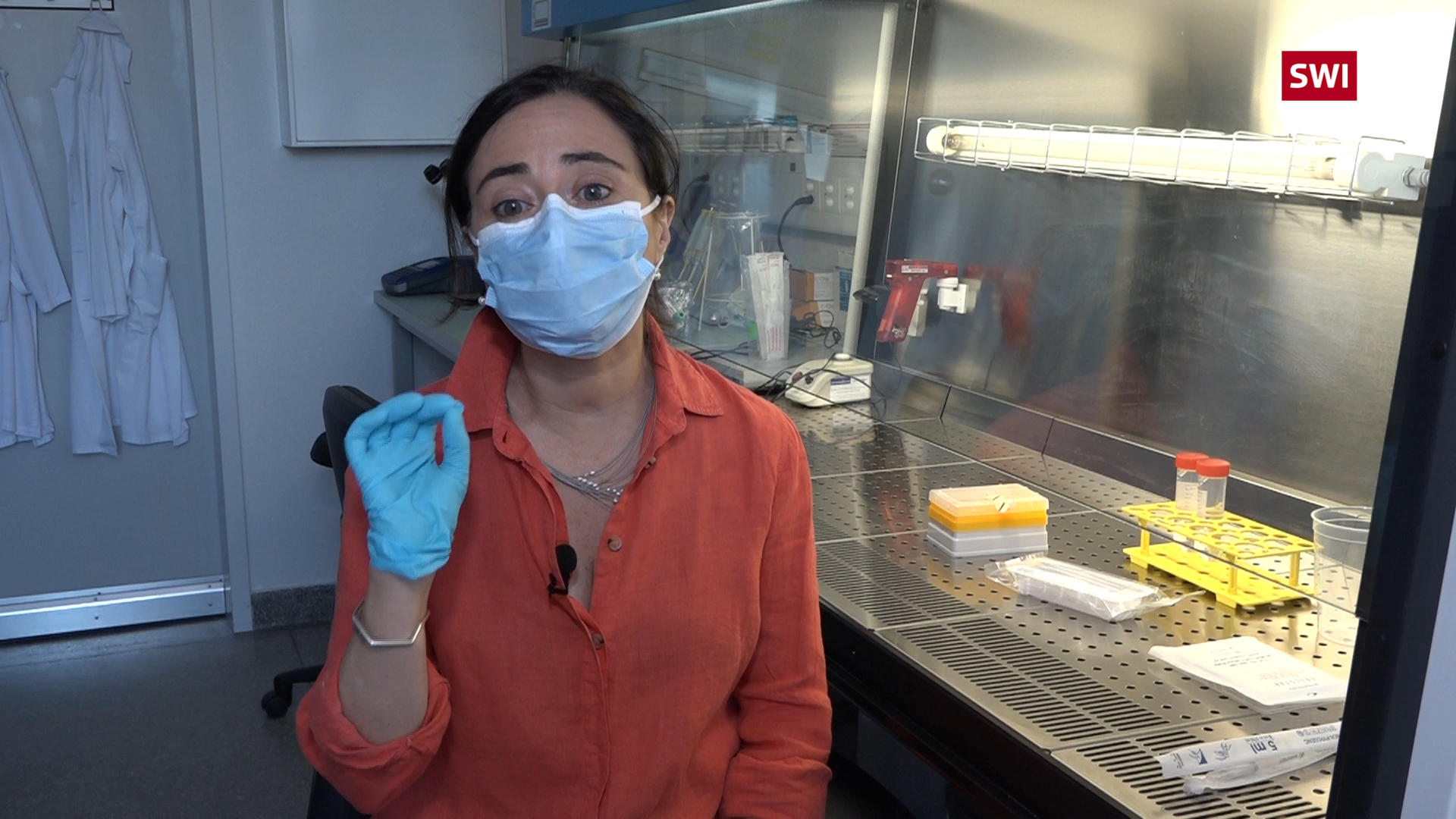 Científica en laboratorio con guantes y mascarilla