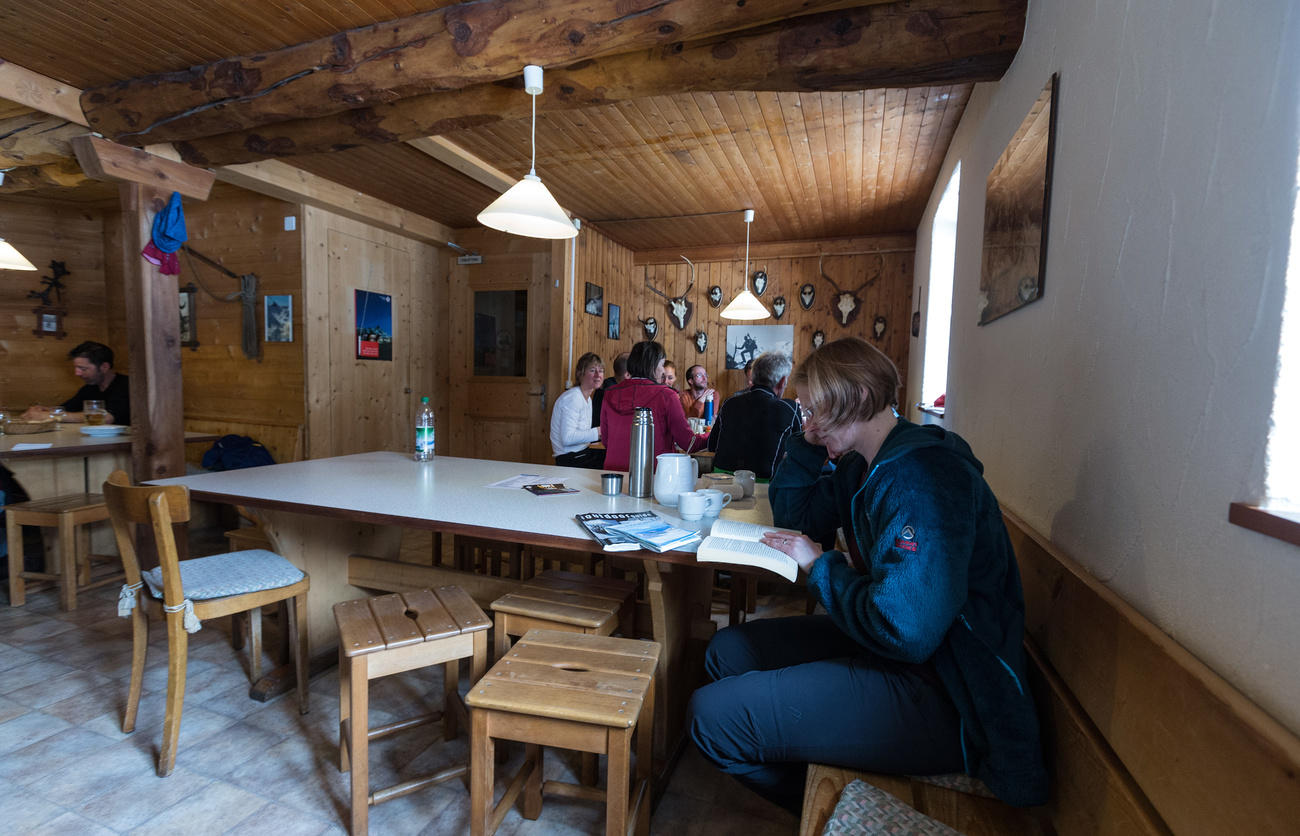 Menschen sitzen in einem Raum an Tischen und lesen.