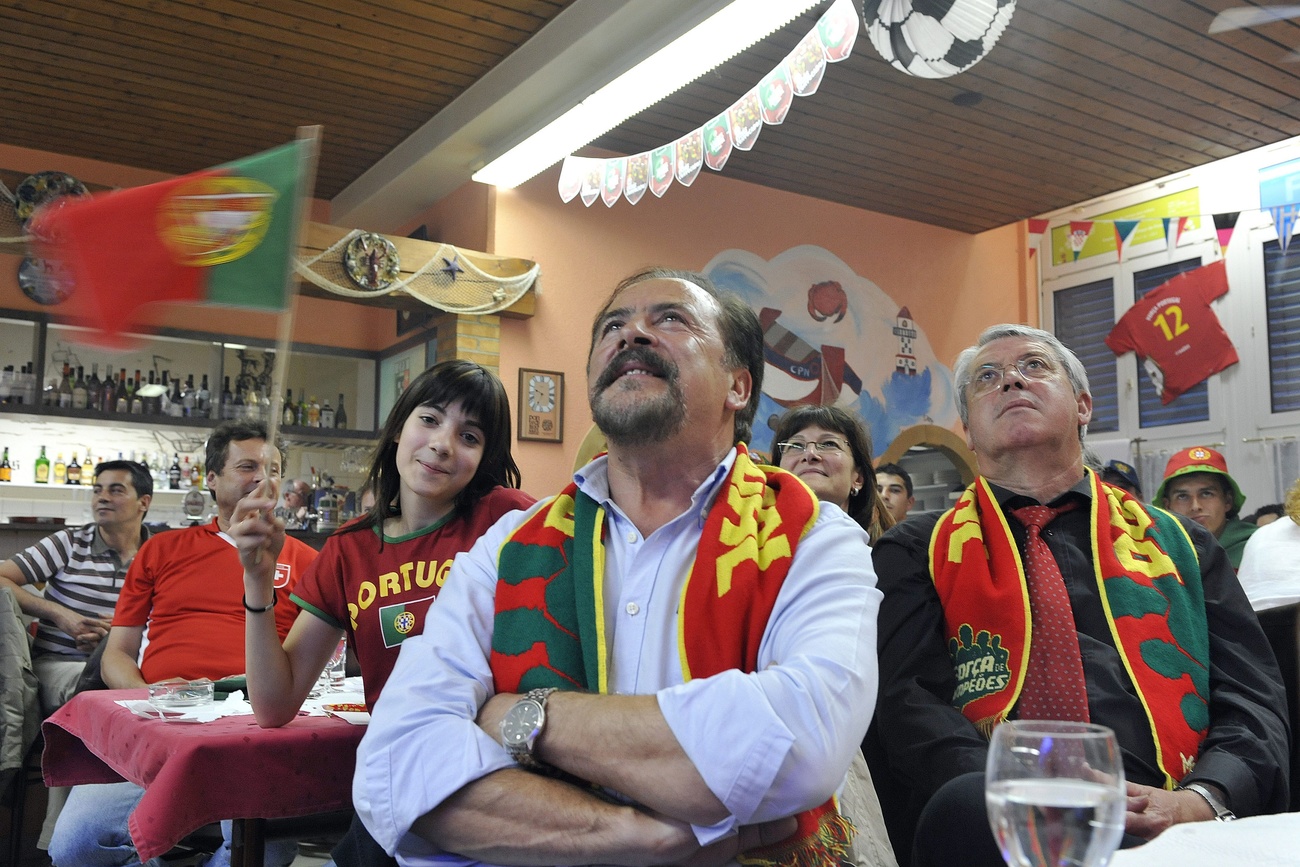 Pessoas assistindo televisão em um bar