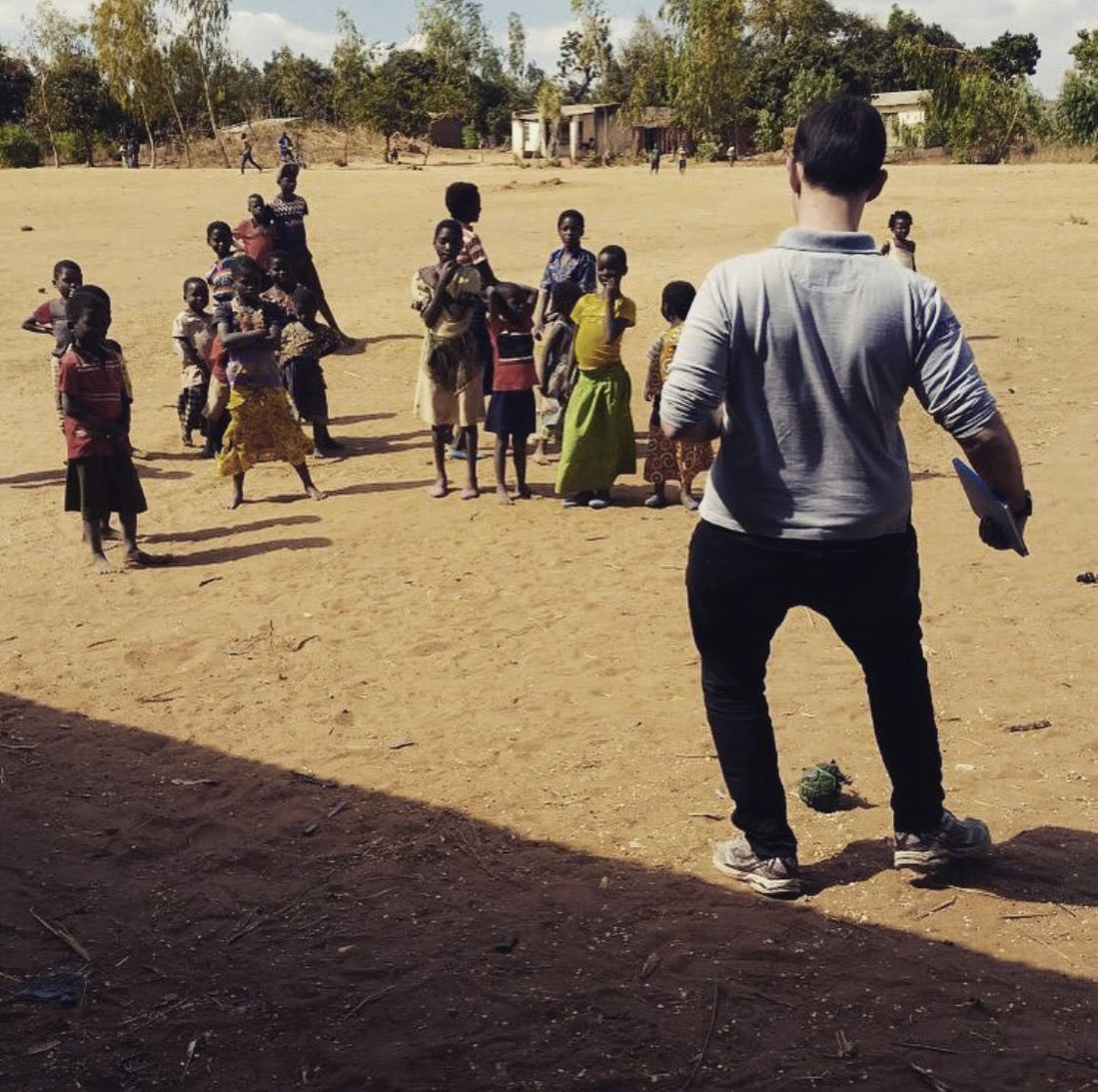 Homem jogando bola com crianças