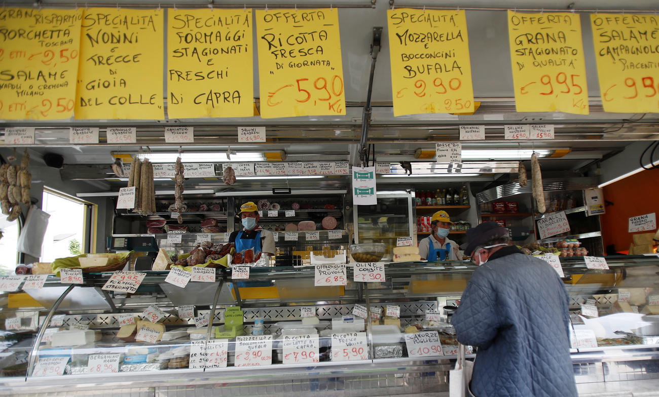 Un venditore di salumi e formaggi al mercato.