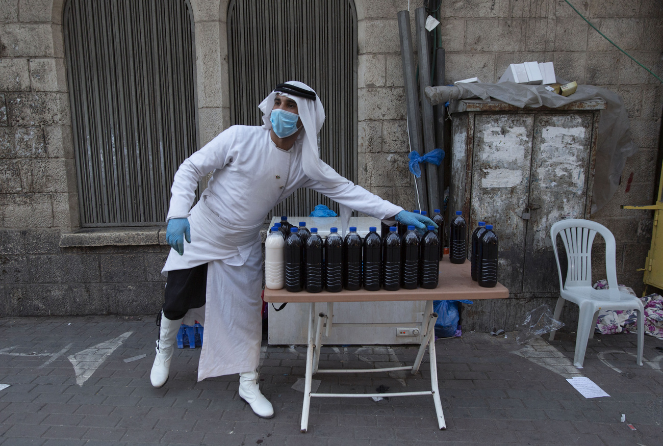 Vendedor con mascarilla en un puesto callejero vende bebidas embotelladas