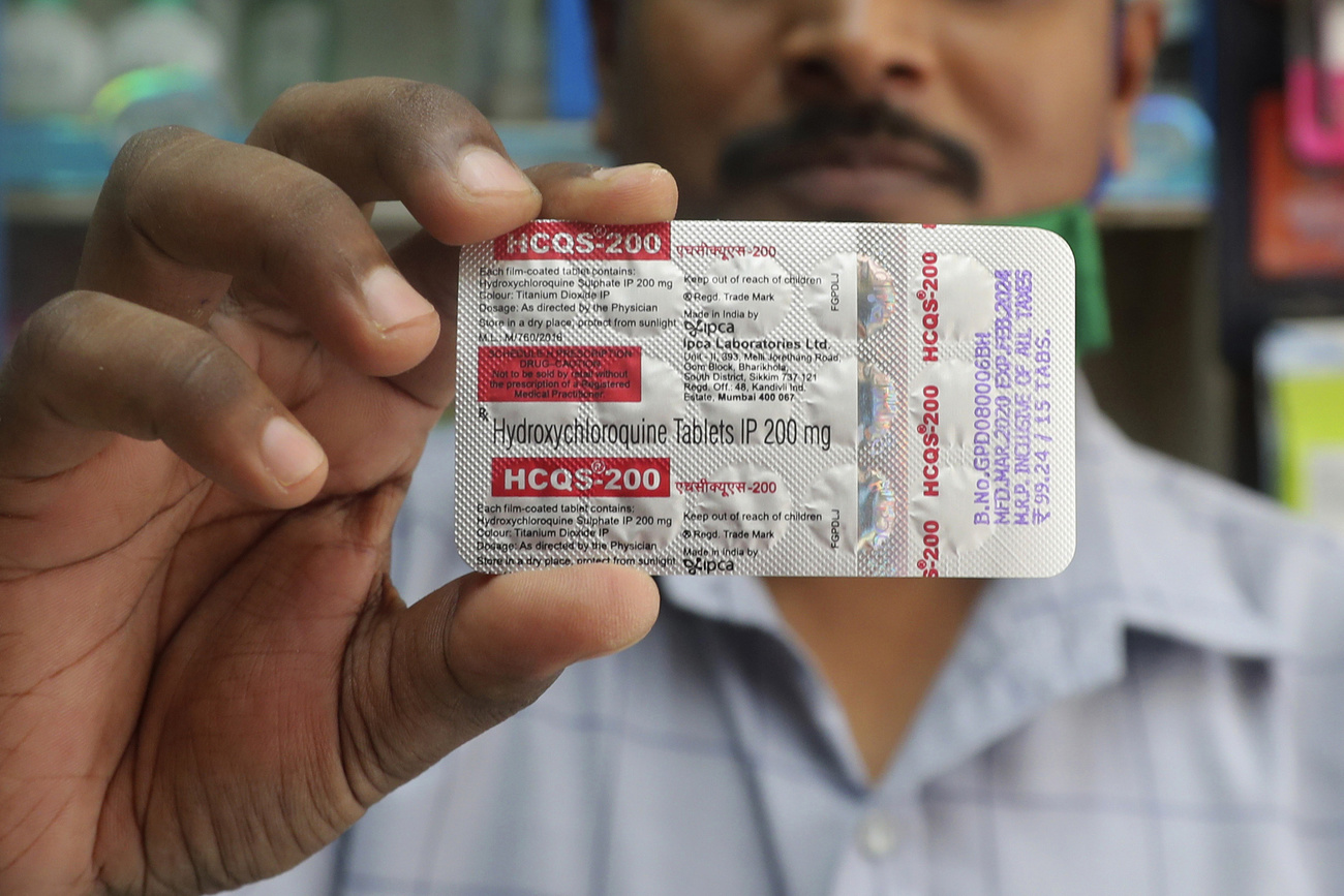 Man holding packet of hydroxychloroquine tablets