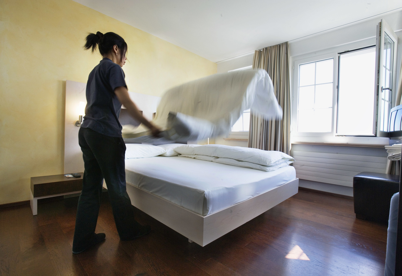 женщина заправляет кровать в отеле