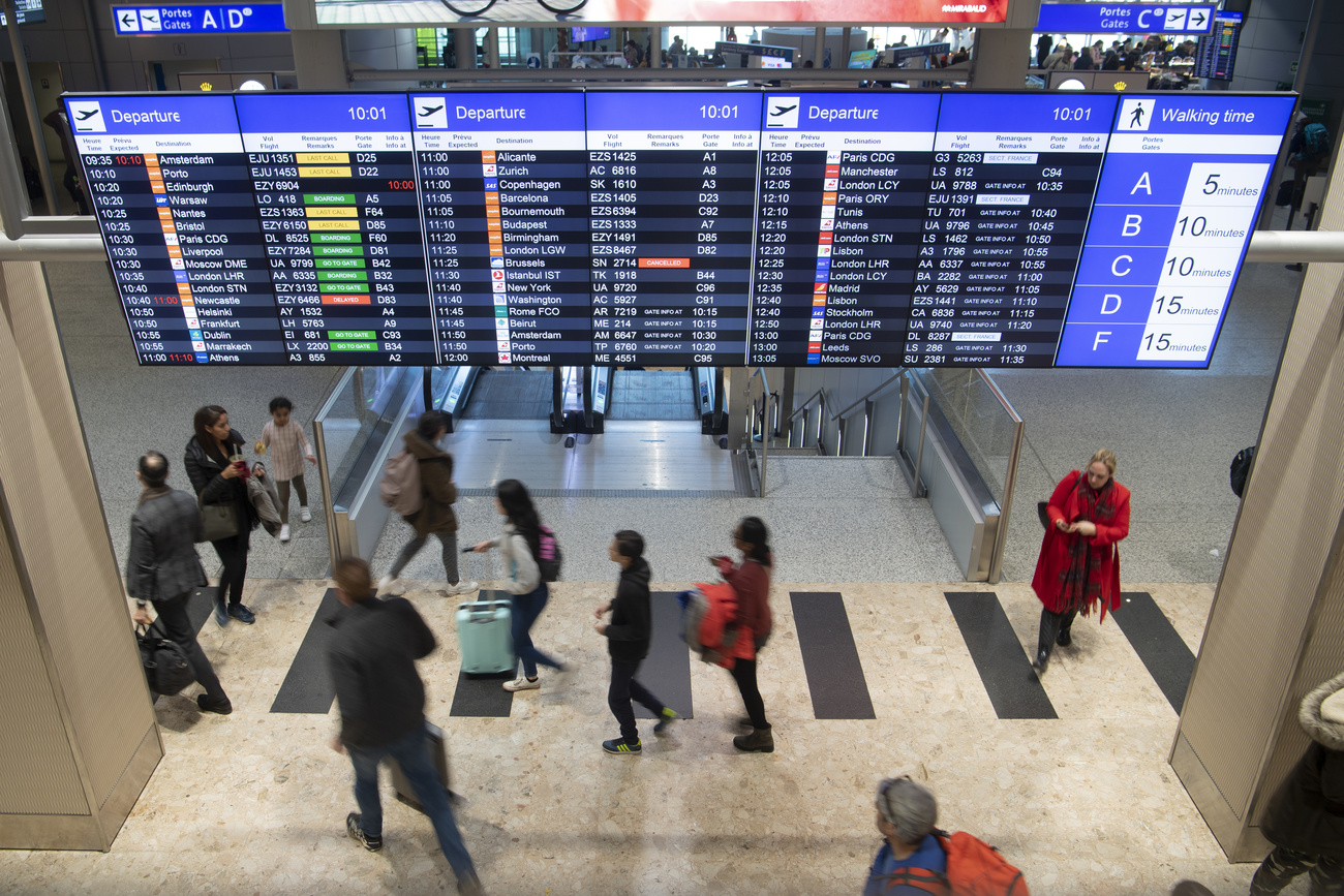 Pessoas sob o quadro de embarque em um aeroporto