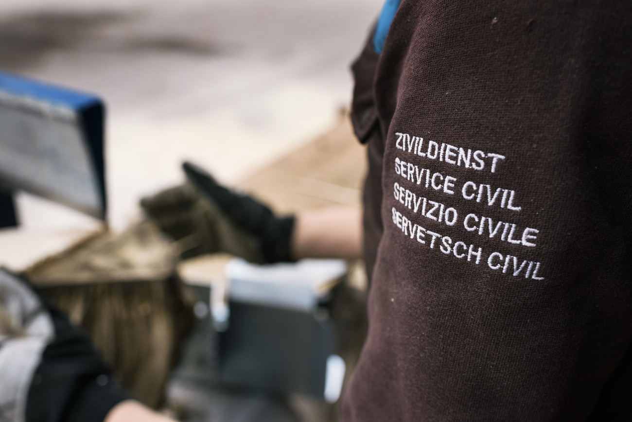 Persona con giacca con la scritta servizio civile in quattro lingue.