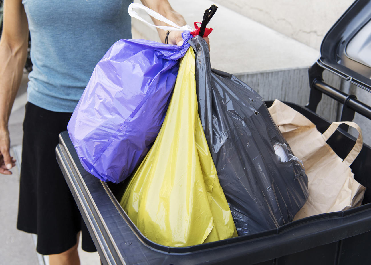 hand carrying trash bags