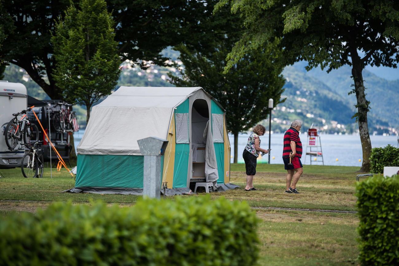 campeggiatori con tenda in riva a un lago