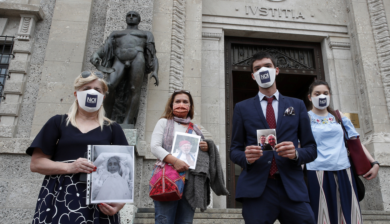 Persone con foto davanti a edifico