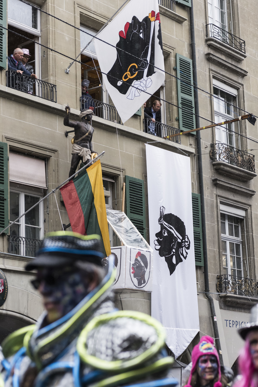 Bandera flotando desde una fachada con la imagen de la cabeza de un negro