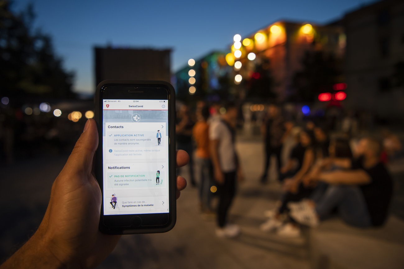 Hand with smartphone in front of group of people