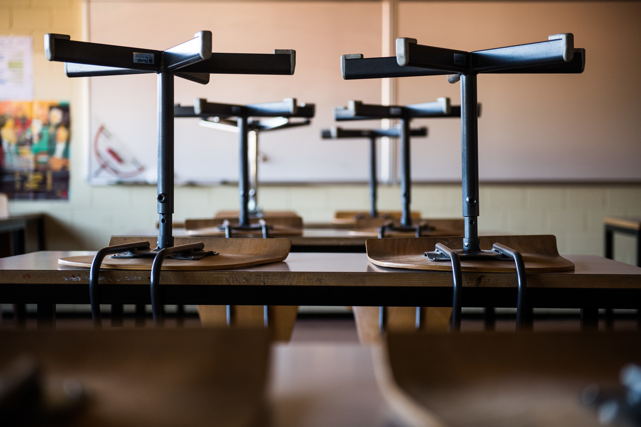 Sedie capovolte sui banchi di scuola.