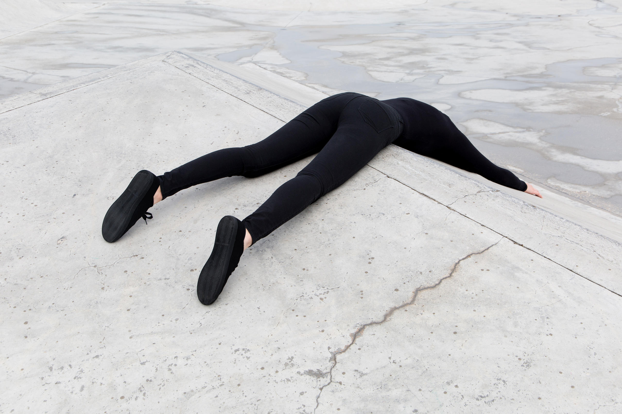 Person dressed in black lying face down