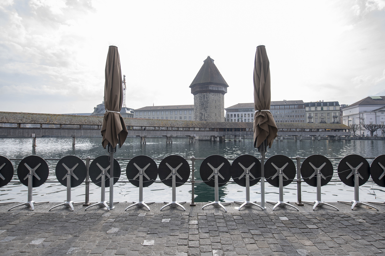 Una fila di tavolini chiusi davanti al famoso ponte di Lucerna.