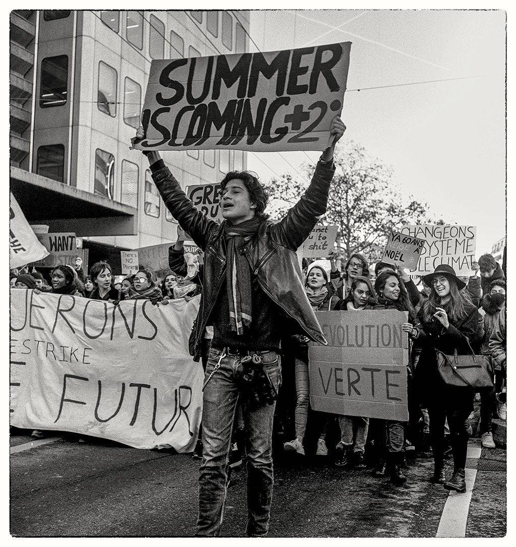 شبان يحملون لافتات في مظاهرة من أجل المناخ بمدينة لوزان