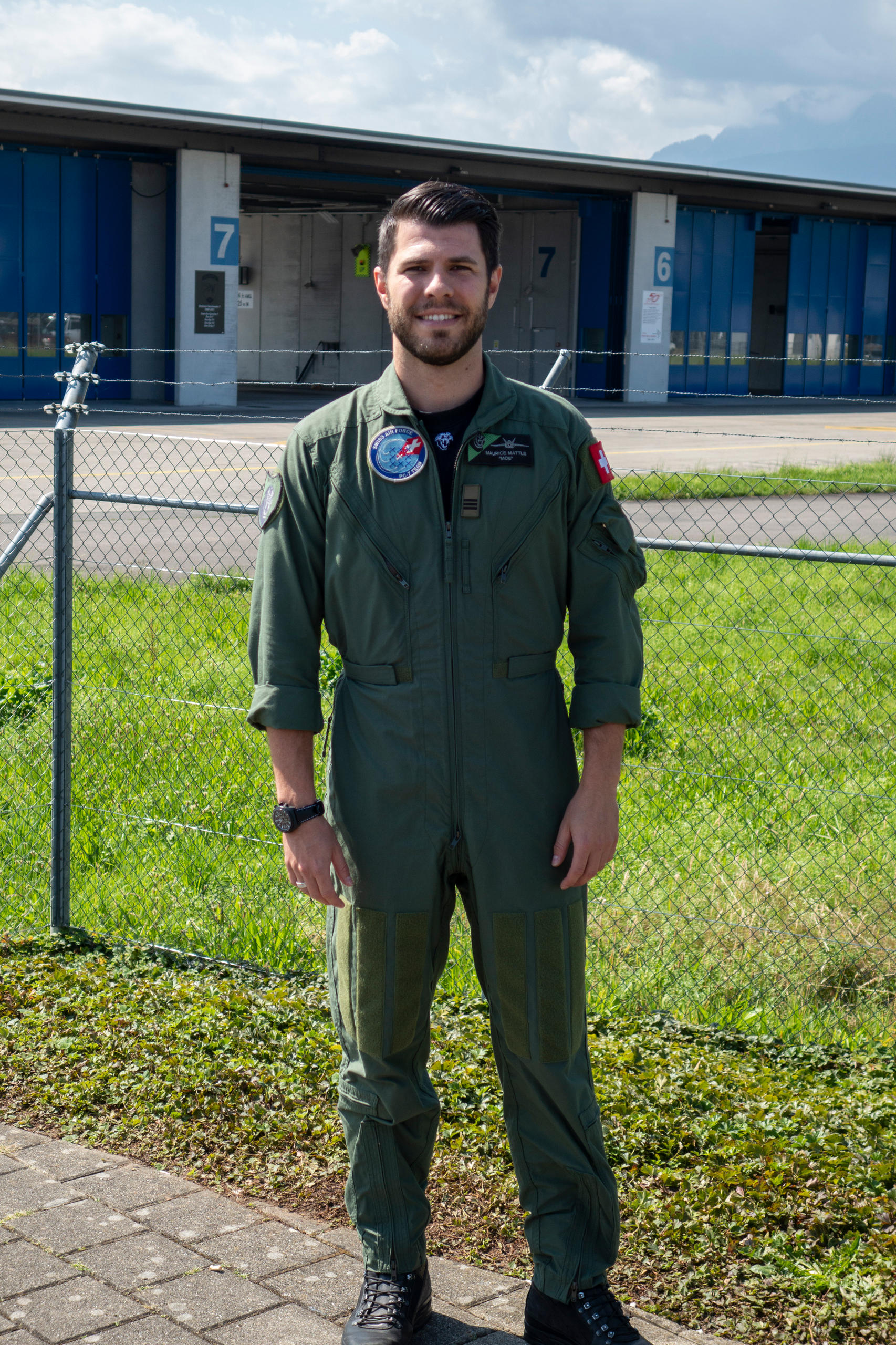 Maurice Mattle in piedi davanti alla base aerea.