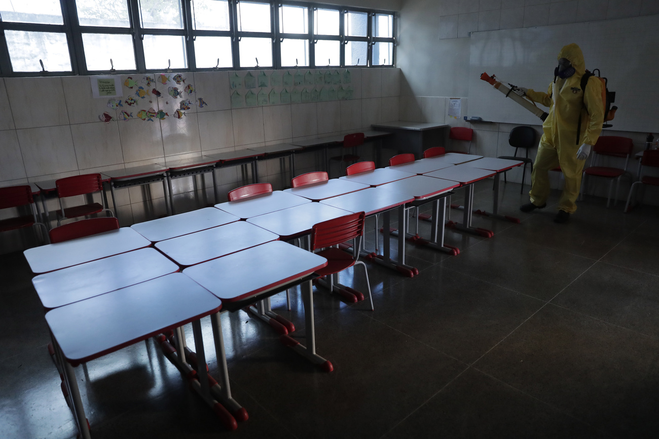 Un employé désinfecte une salle de classe au Brésil.