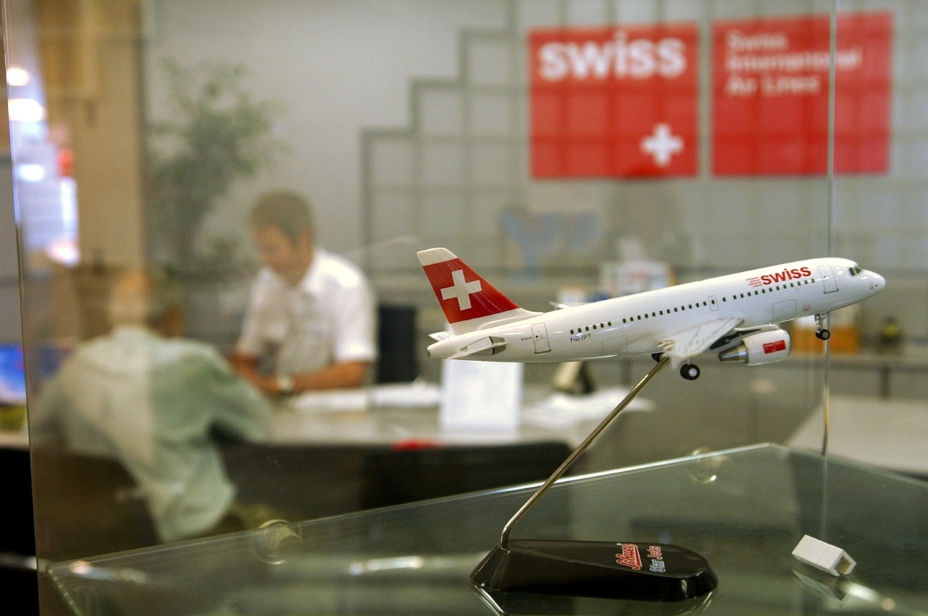 Model airplane and two men at sales counter