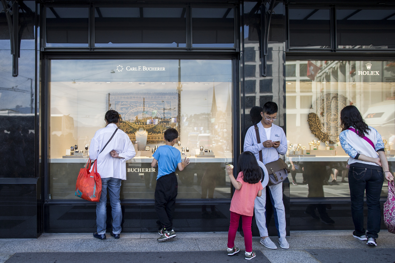 Asian tourists looking in a Swiss watch window