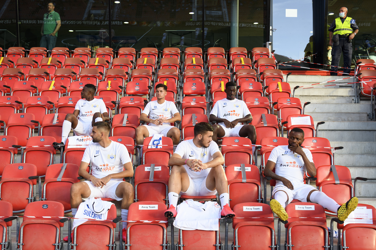 Giocatori dello Zurigo seduti in tribuna con la giusta distanza.