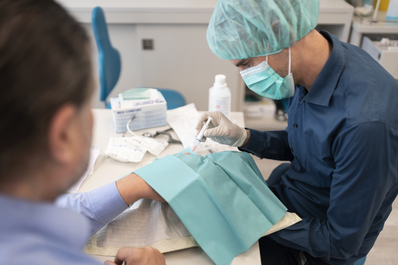 Doctor with protective mask treats patient